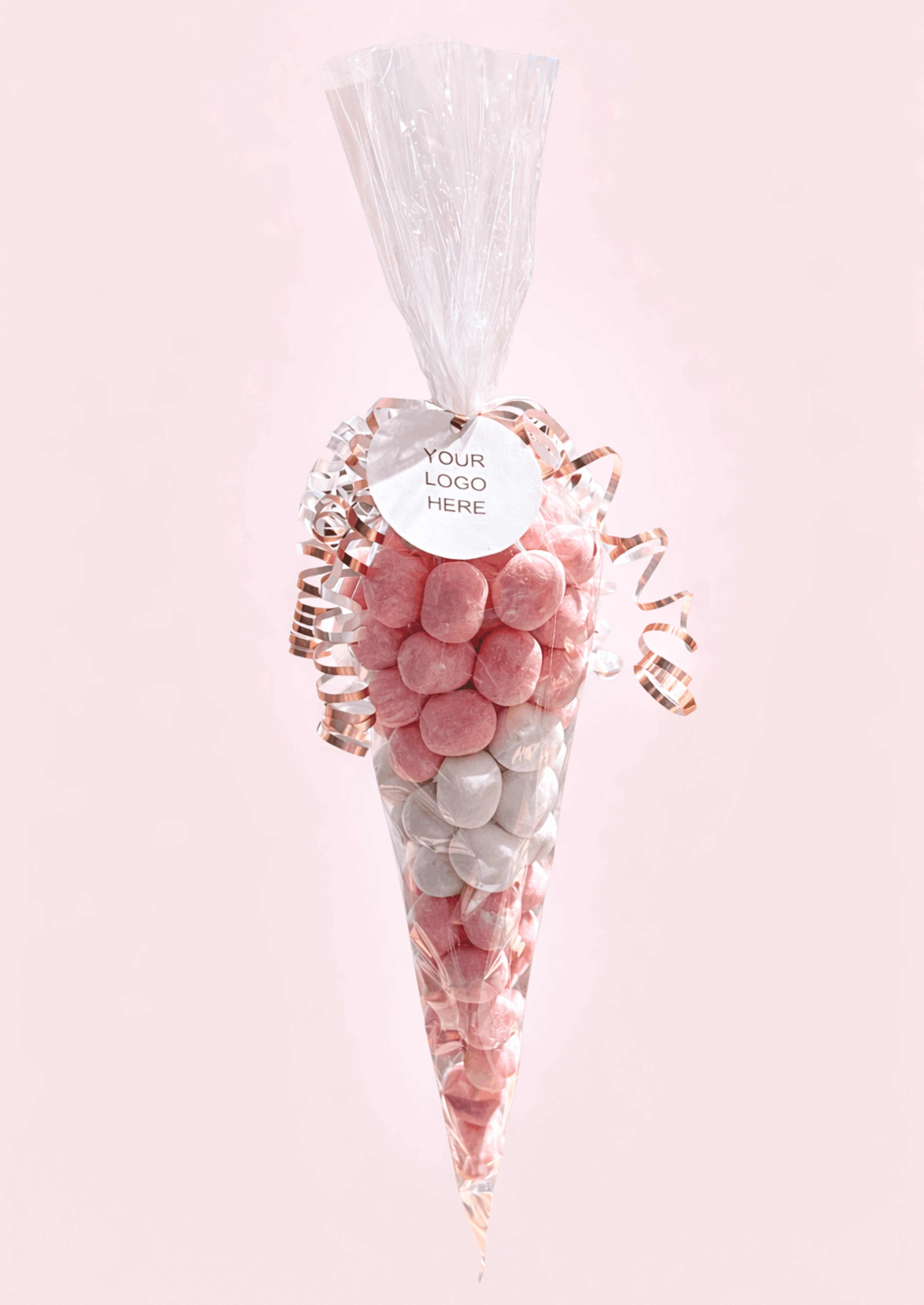 Decorative candy cone with pink and white candies on a light pink background
